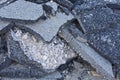 Cracked asphalt pieces after demolition of a road surface in a construction site for renovation ready to be recycled