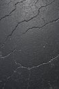 Cracked black asphalt surface, texture, pattern, background. Vertical photo. Flat lay. Royalty Free Stock Photo