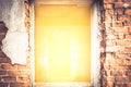 Cracked brick wall with bright yellow light from entrance with effect of light at the end of the tunnel Royalty Free Stock Photo