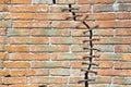 Cracked brick wall with with a metal seam - concept image