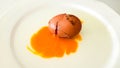 Cracked brown egg with yolk on white plate Royalty Free Stock Photo