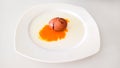 Cracked brown egg with yolk on white plate Royalty Free Stock Photo