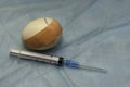 a cracked chicken egg sealed with a medical plaster next to a syringe concept vaccination immunization medical care