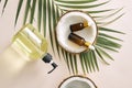 Cracked coconut and a bottle of oil on the table - spa, skincare, haircare and relaxation concept