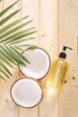 Cracked coconut and a bottle of oil on the table - spa, skincare, haircare and relaxation concept