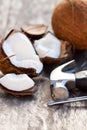 Cracked coconuts and hammer on old wooden table Royalty Free Stock Photo
