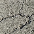 Cracked concrete surface with visible small pebbles and rough texture. The cracks Royalty Free Stock Photo