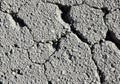 Cracked, dry gray earth forms irregular, rough-textured patterns with visible pebbles Royalty Free Stock Photo