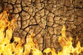Cracked dry soil of earth texture with fire flames. Royalty Free Stock Photo