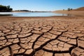 Cracked earth with dried up lake in background. Global warming and water scarcity concept Royalty Free Stock Photo