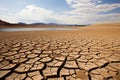 Cracked earth with dried up lake in background. Global warming and water scarcity concept Royalty Free Stock Photo