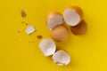 cracked egg shell isolated on yellow background, ingredients for cookings Royalty Free Stock Photo