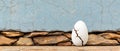 A cracked egg sits on a stone wall Royalty Free Stock Photo
