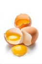 A cracked egg spills its golden yolk on a stark white surface, accompanied by other eggs and shells, creating a bright breakfast Royalty Free Stock Photo