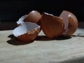 Cracked eggshell on wooden cutting board with black background