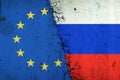 Cracked Euro Union and Russia flags. Rupture of economic relations. Sanctions. Economic crisis. War between Russia and Ukraine
