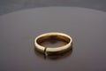 Cracked gold wedding ring on wooden background. . Divorce concept