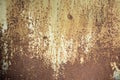 Cracked green paint peeling off rusty metal sheet panel. Brown weathered grunge texture. Royalty Free Stock Photo