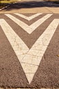 Cracked and grungy directional arrows painted on residential street - very textured asphalt with regular pavement with tree Royalty Free Stock Photo