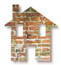 Cracked house concept image with house icon against a brick wall background Royalty Free Stock Photo