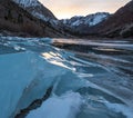 Cracked ice on a frozen lake captures sunset light Royalty Free Stock Photo
