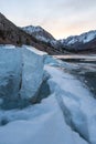 Cracked ice on a frozen lake captures sunset light Royalty Free Stock Photo