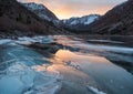 Cracked ice on a frozen lake captures sunset light Royalty Free Stock Photo