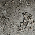 Cracked pavement surface with a rough texture, revealing small stones and pebbles Royalty Free Stock Photo