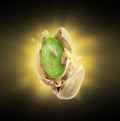 A cracked pistachio with a flash of light in the dark Royalty Free Stock Photo