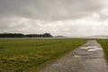 Cracked road and green fields at Herdla Askoy, outside the city of Bergen, Norway