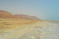 Cracked shore of the dead sea against the background of the Judean mountains Royalty Free Stock Photo