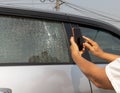 Cracked side car window glass on road . Damaged car window. Car accident claims via insurance apps