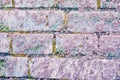 Cracked soft pink paint, plaster surface on brick wall with yellow accents, grunge horizontal shabby background detail Royalty Free Stock Photo