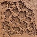 Cracked surface displaying a dry, clay-like texture covering a wire mesh Royalty Free Stock Photo
