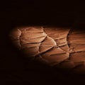 Cracked surface with a spotlight highlighting the texture. The dry, fragmented groun Royalty Free Stock Photo
