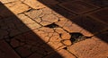 Cracked Terracotta Pavement with Dramatic Sunlight and Shadow Royalty Free Stock Photo