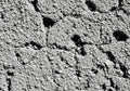 Cracked, textured concrete surface featuring small pebbles embedded in the material. Royalty Free Stock Photo