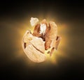 A cracked walnut with a flash of light in the dark Royalty Free Stock Photo