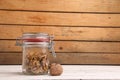 Cracked walnuts in the glass jar on the wooden surface Royalty Free Stock Photo