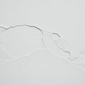 Cracked white wall surface with several irregular fractures and peeling. The texture Royalty Free Stock Photo