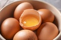 Cracked and whole chicken eggs in bowl, closeup Royalty Free Stock Photo