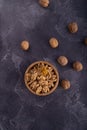 Cracked and whole walnuts in wooden bowl and on dark slate surface. Healthy nuts and seeds composition. Royalty Free Stock Photo