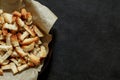 Crackers, baked dried white bread slices on craft paper, on dark background, top view, space to copy text Royalty Free Stock Photo