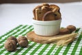 Crackers with raisins in a white bowl, walnuts, dry ears, green textiles