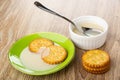 Crackers in saucer with condensed milk, spoon in bowl with milk, cookies on table Royalty Free Stock Photo