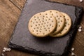 Crackers stack together on black stone, coarse sugar on wooden b Royalty Free Stock Photo