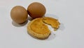 Cracking egg tart with two chicken eggs isolated on white