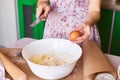 Woman put ingredients for apple pie into big white bowl. Preparing dough in the kitchen Royalty Free Stock Photo