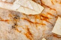 Cracks and blotches on the surface of beige marble close-up