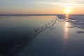 Cracks with ice crystals on frozen river at sunset Royalty Free Stock Photo